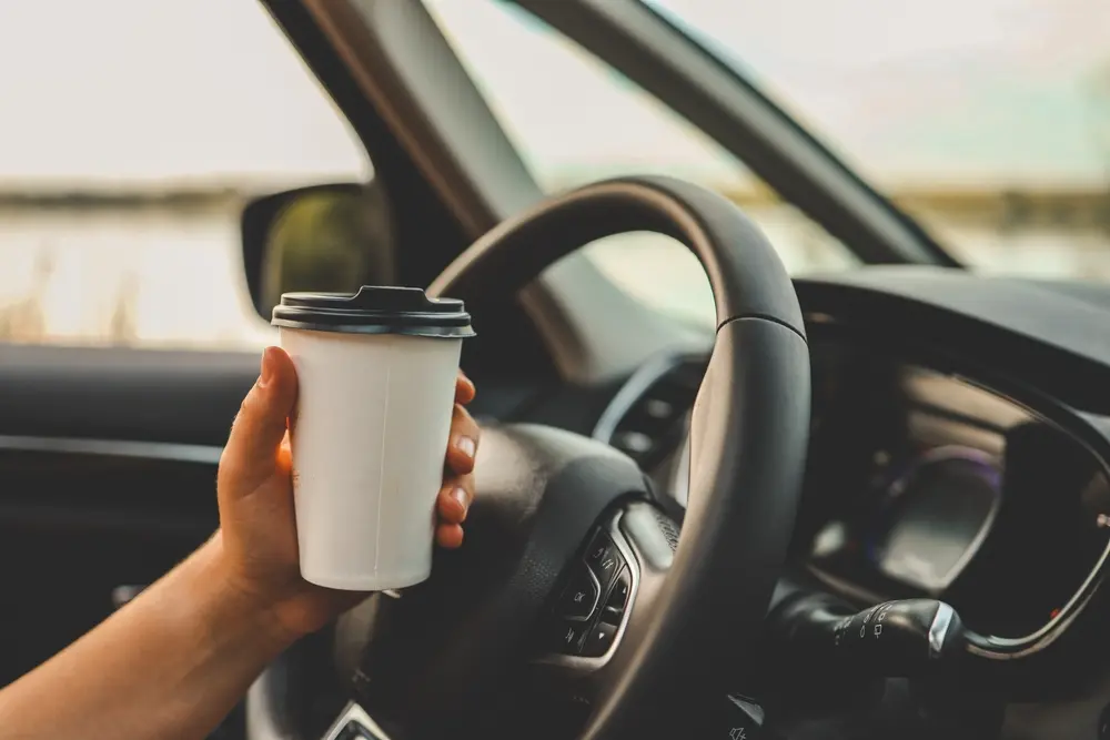 To-go coffee cup held inside a car near Floyd Xpress Market in Floyd, VA