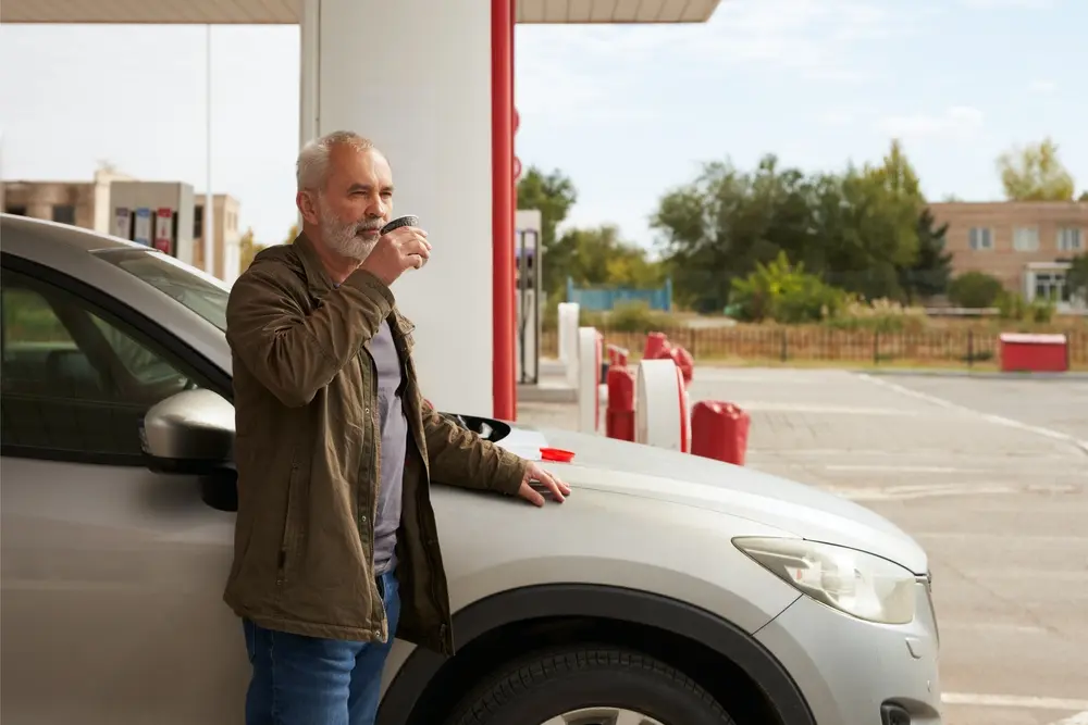Elderly man drinking coffee beside his car at Floyd Xpress Market in Floyd, VA