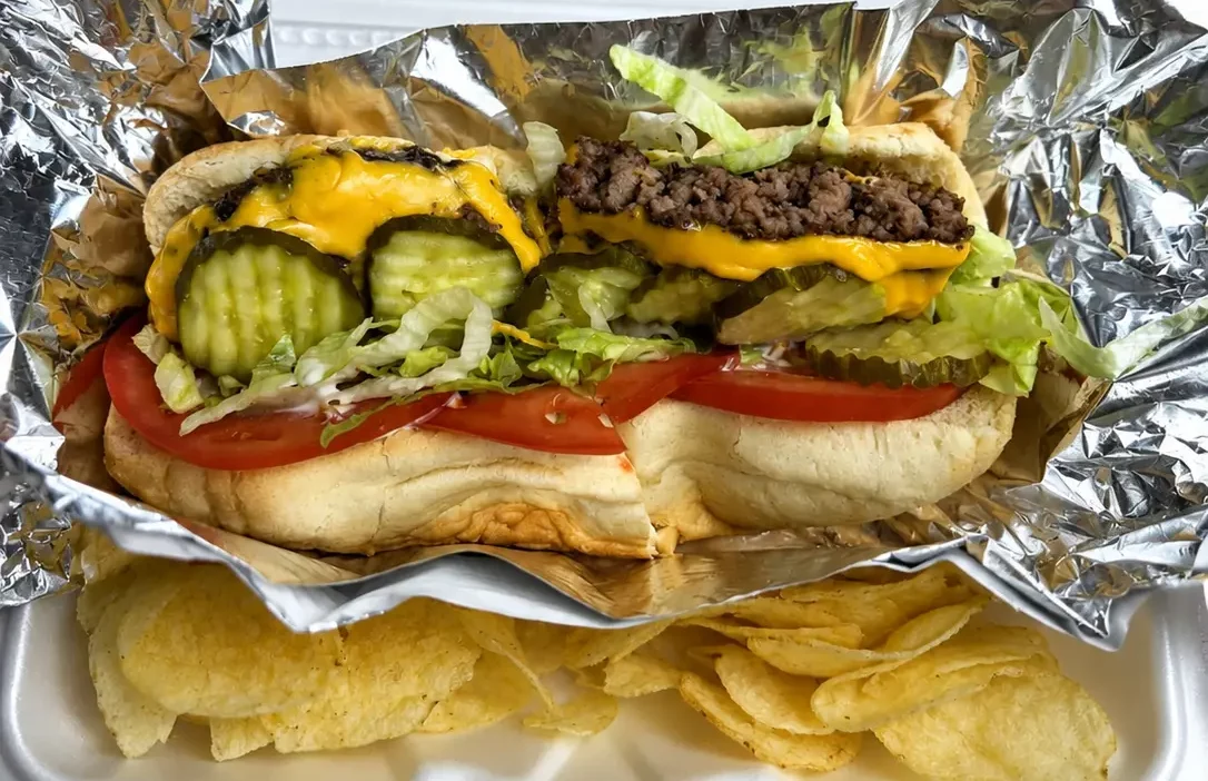 Fresh deli sandwich with meat, tomato, lettuce, cheese, pickles, and chips at Floyd Xpress Market in Floyd, VA