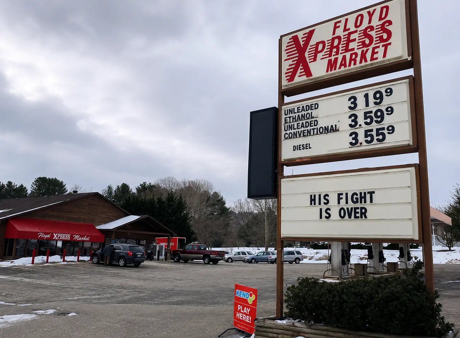Floyd Xpress Market signs with store logo, gasoline prices, and His Fight Is Over message in Floyd, VA
